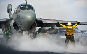 An EA-6B Prowler is about to launch from a US Navy Carrier with AN/ALQ-99 Low Band Transmitters installed under its wing pylons.